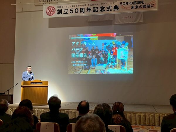 聴衆に向けてアクトキッズパークの事業報告をする遠藤朋樹(帯広ローターアクトクラブ50周年記念式典)
